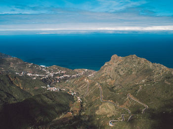 Scenic view of sea and mountains against sky