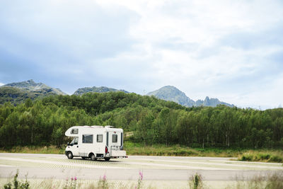 Motor home on road by mountain against sky