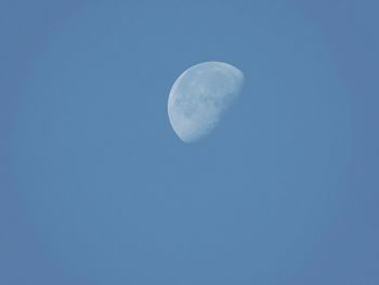 Low angle view of moon in blue sky