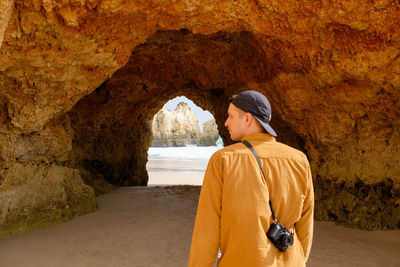 Rear view of man standing against rock formations