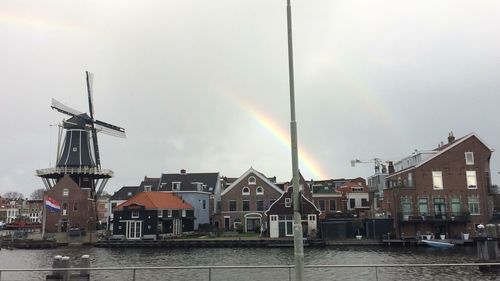 View of rainbow over houses against sky