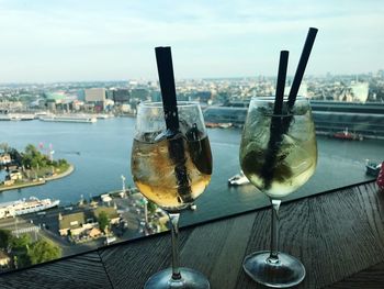 Close-up of drink on table by sea against sky