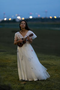 Bride in a wedding dress plays the ukulele a hawaiian fourstringed guitar