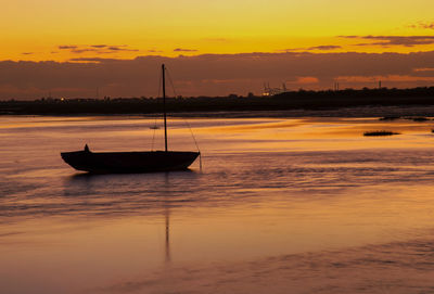 Boat moored on sea against sky during sunset