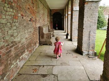 Rear view of girl walking independently though a courtyard 