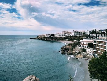 Scenic view of sea by buildings against sky