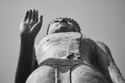 Low angle view of man statue against sky