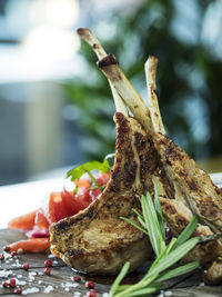 Close-up of lamb chop with rosemary on cutting board