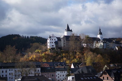 Buildings in town against sky