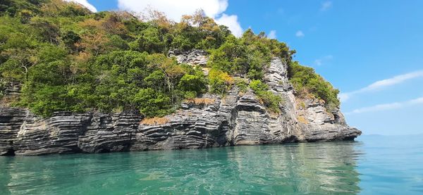 Scenic view of rock formation in sea against sky