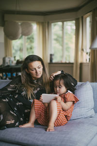 Mother and daughter sitting on floor