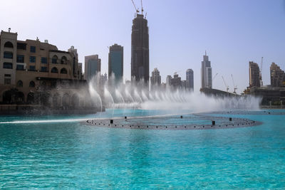 The dancing fountains downtown and in a man-made lake in dubai, uae in front of the burj khalifa