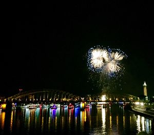 Firework display over river at night