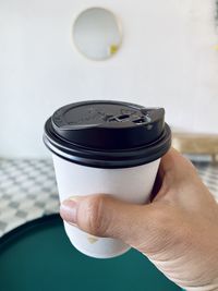 Close-up of hand holding coffee cup