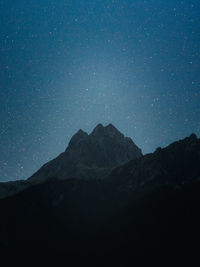 Scenic view of mountains against sky at night