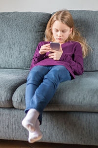 Woman sitting on sofa at home