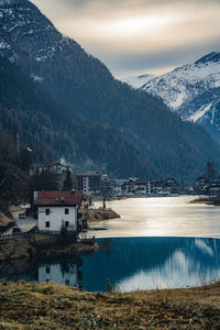Scenic view of lake by buildings against sky