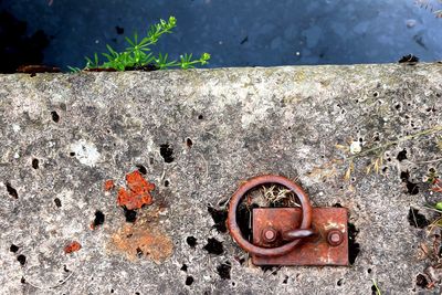 High angle view of rusty metal on concrete wall