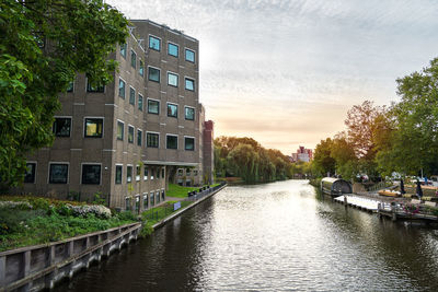 Canal amidst buildings against sky