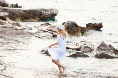 Woman standing on rock at beach