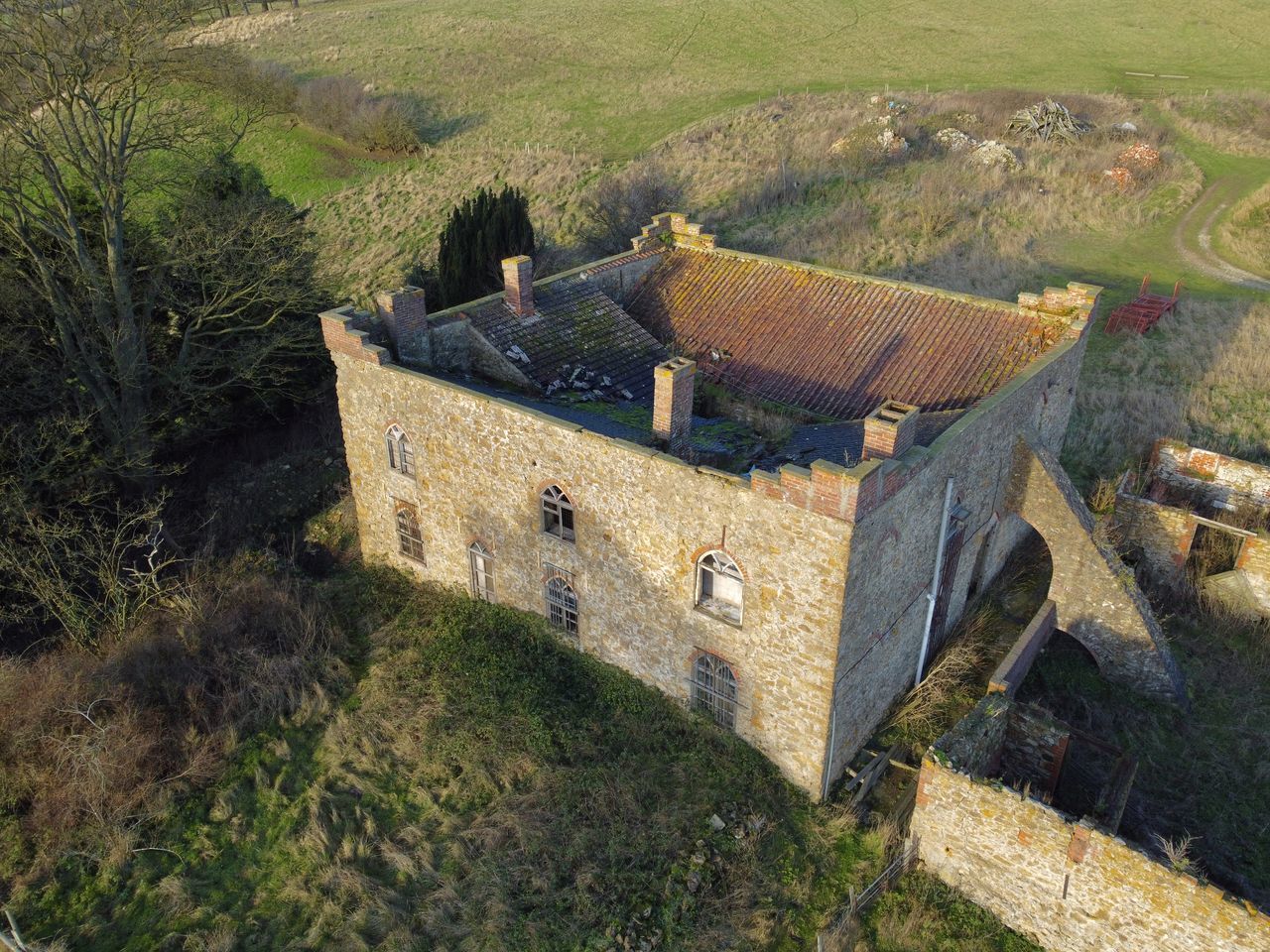 architecture, fortification, built structure, plant, high angle view, building exterior, nature, landscape, land, history, building, the past, rural area, no people, day, field, environment, rural scene, castle, village, ruins, tree, scenics - nature, outdoors, hill, house, agriculture, sunlight, growth, château, grass, ancient, beauty in nature, tranquility, green, old, tranquil scene, residential district, aerial photography, roof