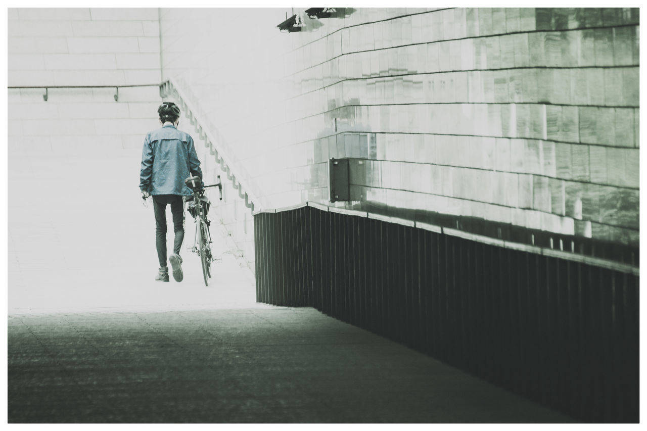 FULL LENGTH REAR VIEW OF MAN WALKING ON FOOTPATH