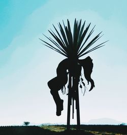 Low angle view of silhouette palm tree against clear sky