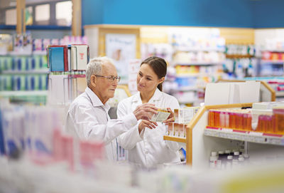 Portrait of woman using mobile phone while standing in laboratory