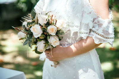 Midsection of woman holding flower bouquet