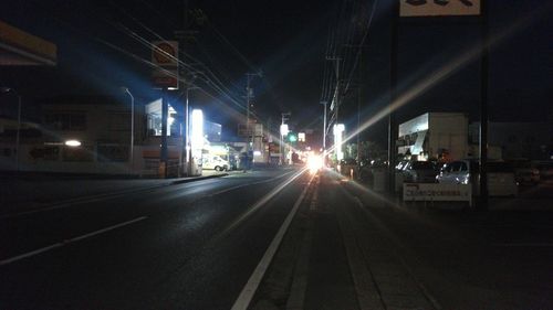 Illuminated railroad tracks in city at night