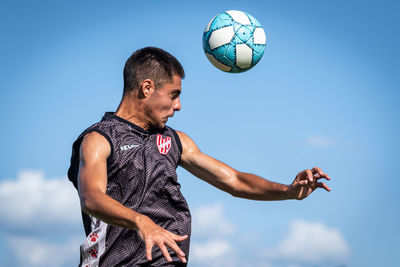 Low angle view of man playing with ball against sky