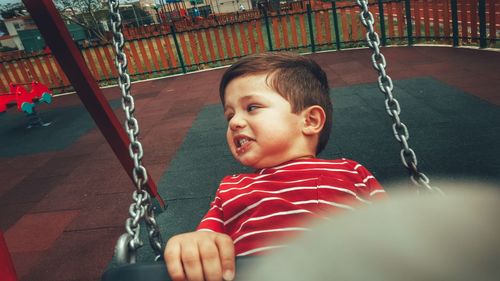 Portrait of young boy on swing