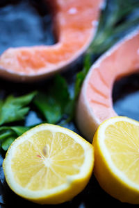 Close-up of lemon slices with herbs and fish on table