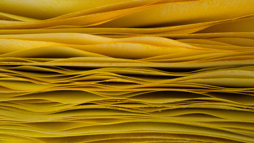 Full frame shot of yellow paper stack