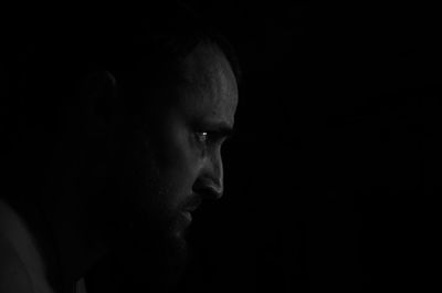 Close-up of man against black background