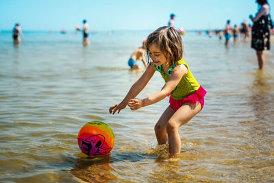 Girl playing with ball at beach