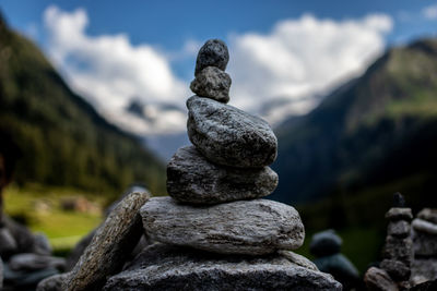 Stack of stones on rock against sky