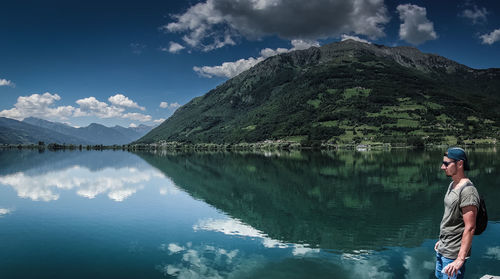 Man standing by lake against sky