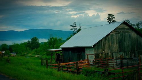 House on field against cloudy sky