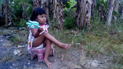 Full length of girl sitting on field