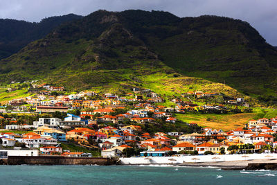 High angle view of townscape by mountains against sky