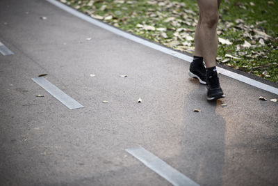 Low section of person walking on road