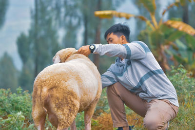 Side view of man with dog on field