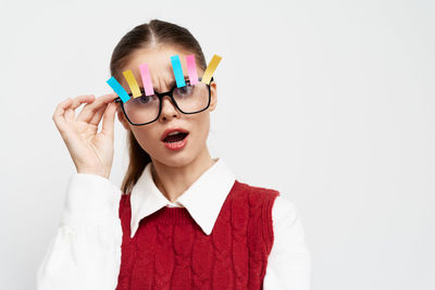 Young woman wearing sunglasses against white background