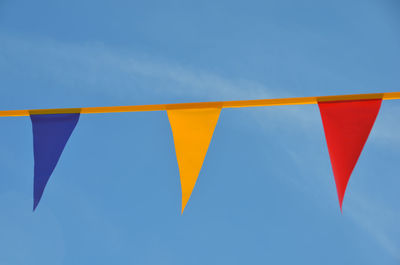 Low angle view of colorful balloons against blue sky