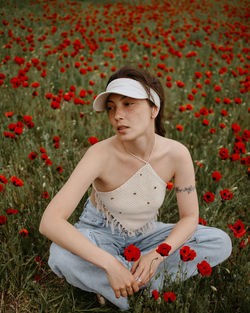 Portrait of young woman standing amidst plants