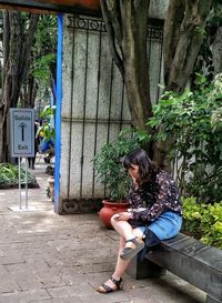 Full length of woman sitting outdoors