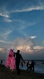 People at beach against sky