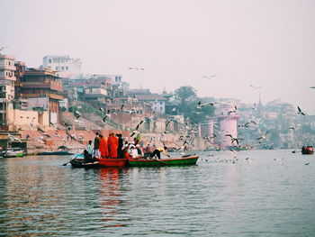 Boats in sea against clear sky