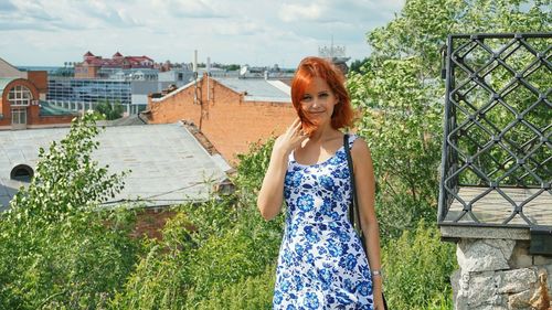Portrait of redhead woman standing in city